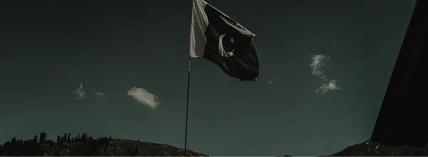 Pakistani flag over a mountain ridge